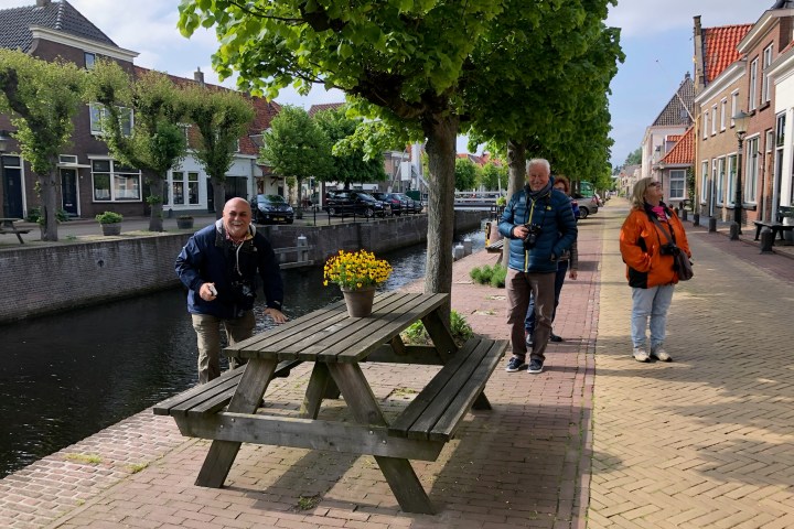 a group of people on a sidewalk near a park bench