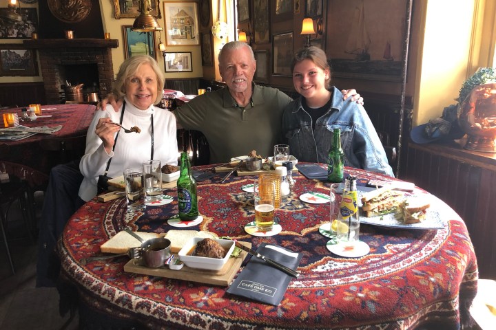 a group of people sitting at a table with a cake