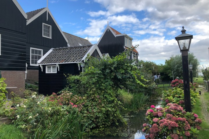 a house with bushes in the background with House of the Seven Gables in the background