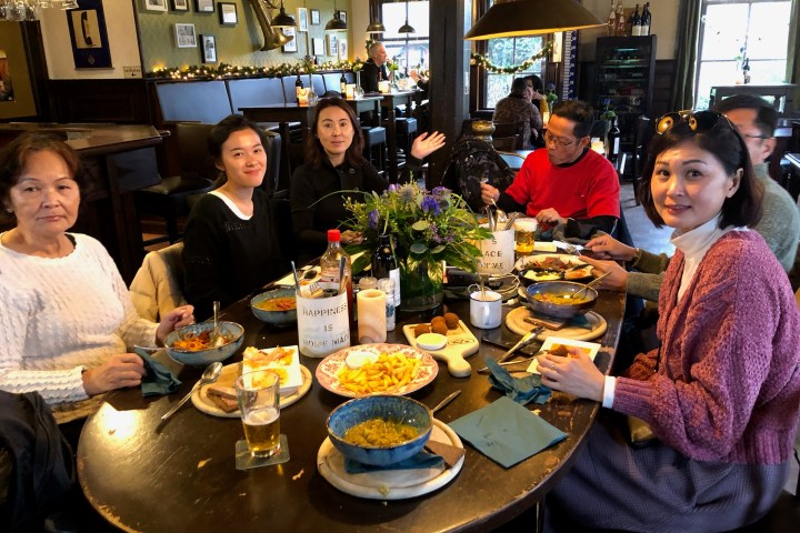a group of people sitting at a table full of food