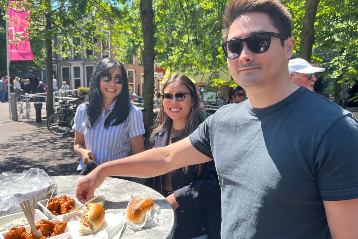 a man and woman preparing food in a park