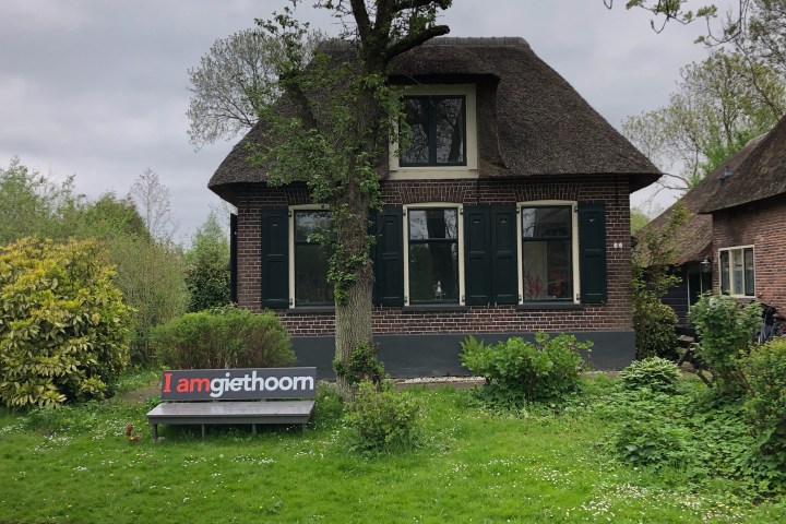 a large brick building with grass in front of a house