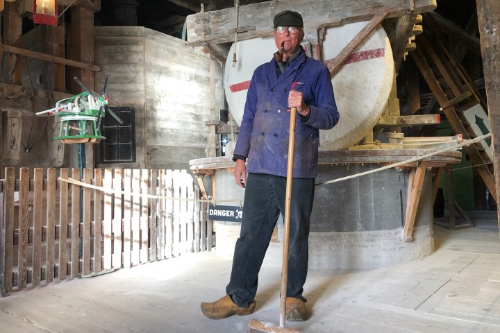 a man standing next to a fence