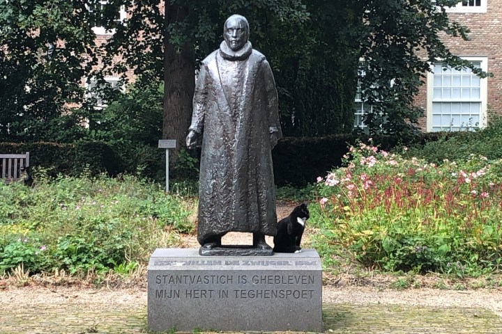 a person sitting on a bench in front of a statue