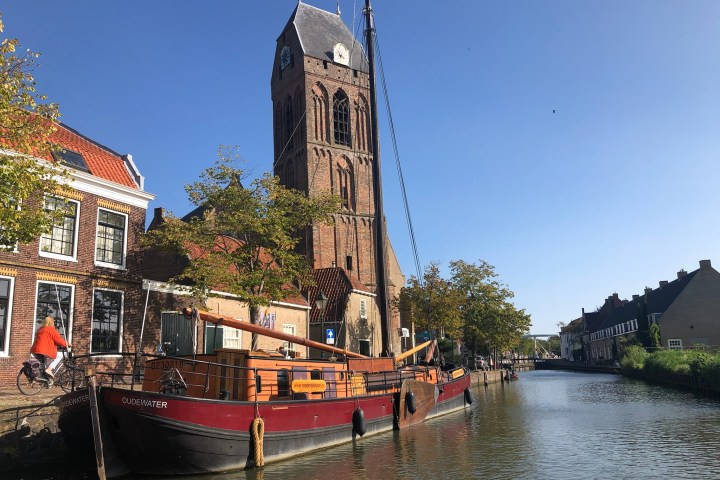 a small boat in a body of water with a city in the background
