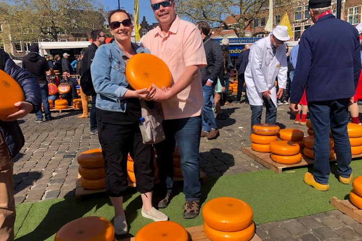 a group of people standing next to an orange frisbee