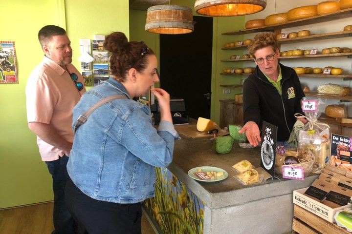 a group of people standing around a table eating food
