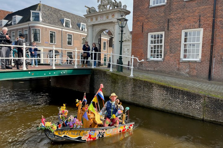 a group of people riding on the back of a boat in the water