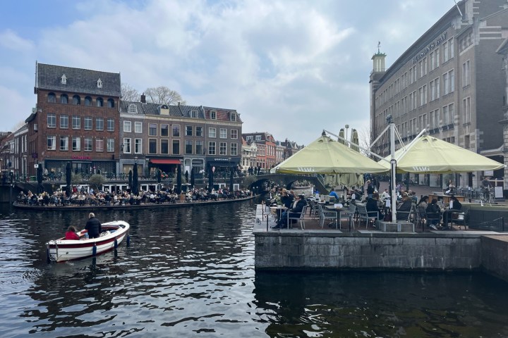 a small boat in a body of water with a city in the background