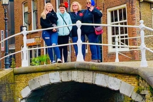 a bridge over a river in front of a brick building