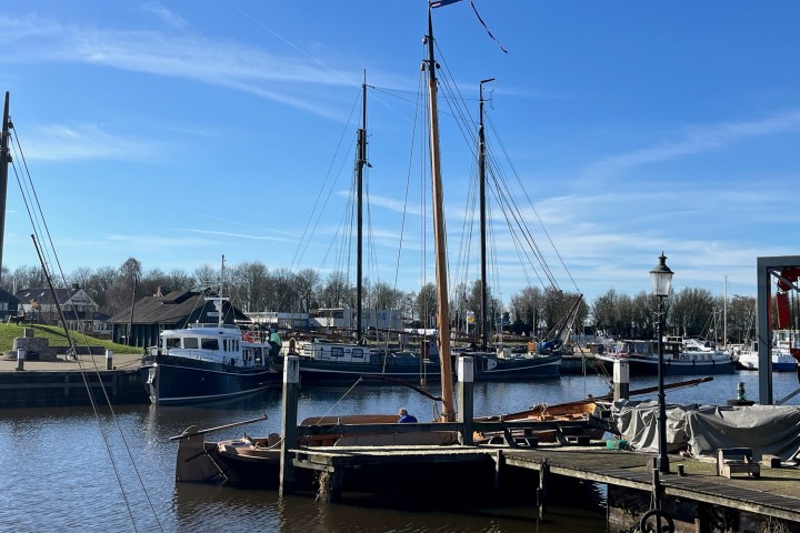 Boats docked at a marina under a clear blue sky.
